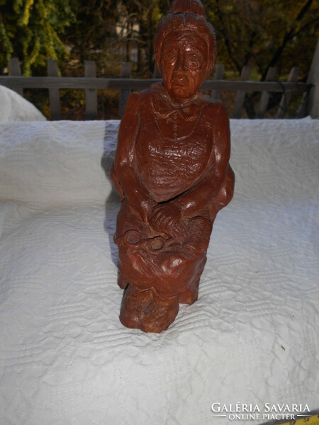 Statue of an old woman with a book and glasses in her lap
