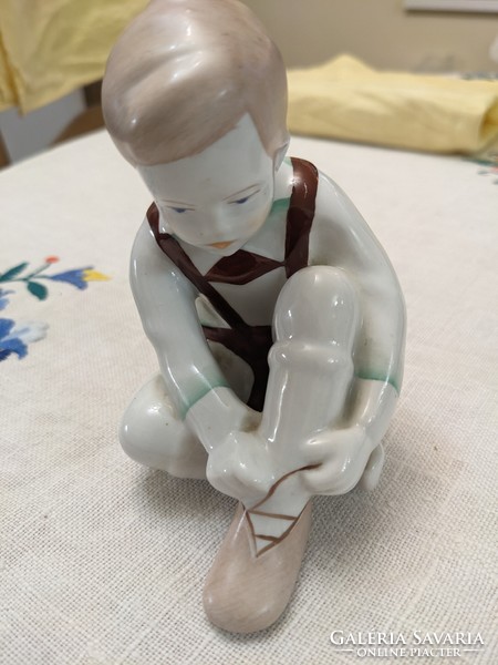 Aquincum porcelain statue of a little boy tying his shoes