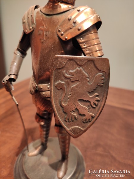 Beautifully crafted red copper plate with a lion on the side of an armored knight on a sword shield