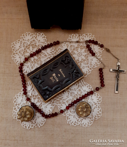 Old nun's heirloom prayer book with buckle, rosary on a lace tablecloth with a gift candle