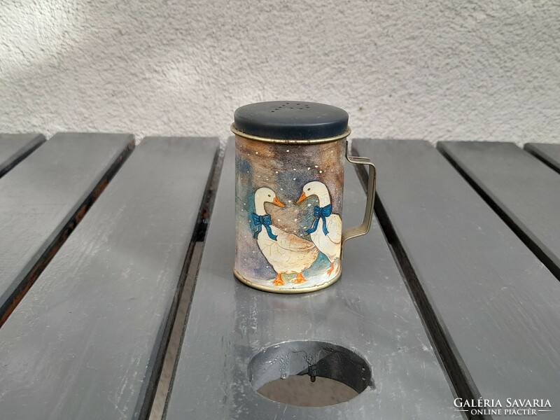 A tiny metal jar, perhaps a children's kitchen accessory