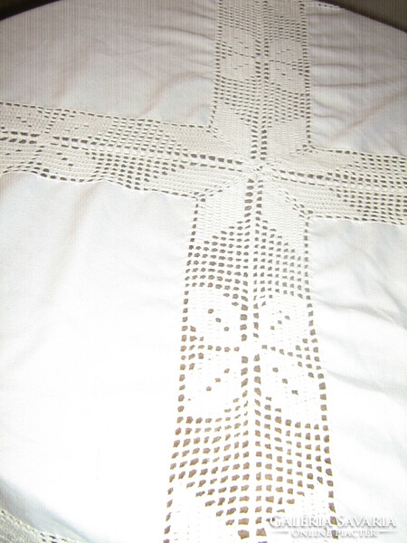 A beautiful tablecloth with a hand-crocheted edge and insert