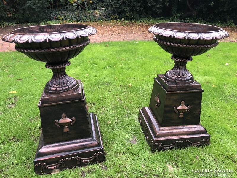 Two large cast iron flowerpots with feet
