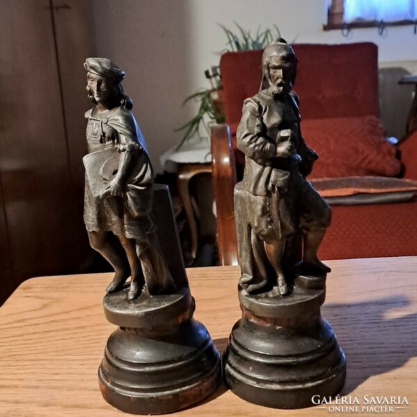 A pair of antique statues, cast iron on a wooden plinth