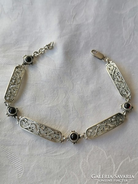 Marked silver openwork pattern bracelet with garnet stones