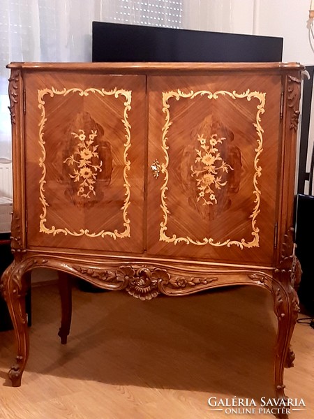 A wonderful baroque high-legged chest of drawers decorated with hand-carvings and hand-inlays, marked piece