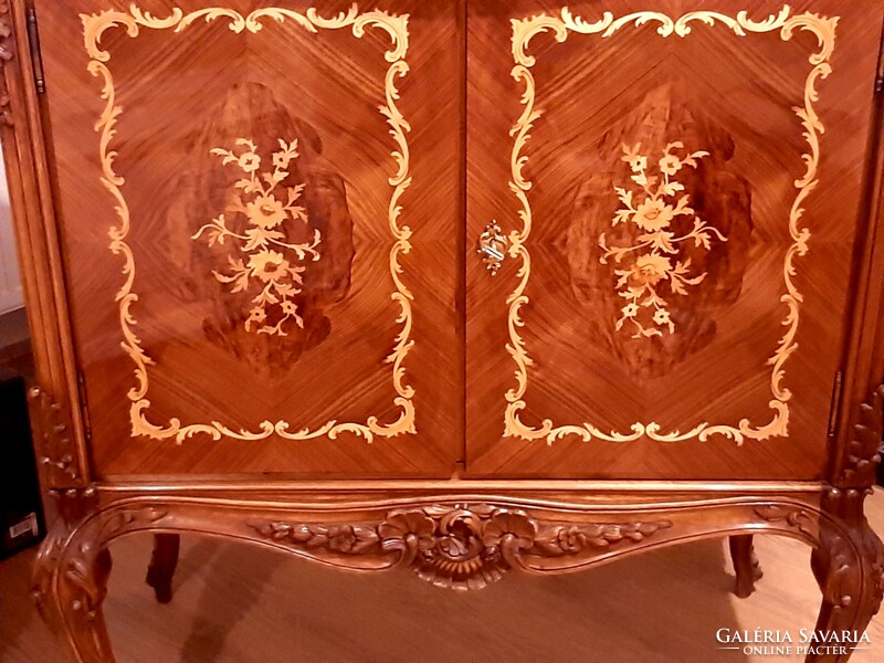 A wonderful baroque high-legged chest of drawers decorated with hand-carvings and hand-inlays, marked piece
