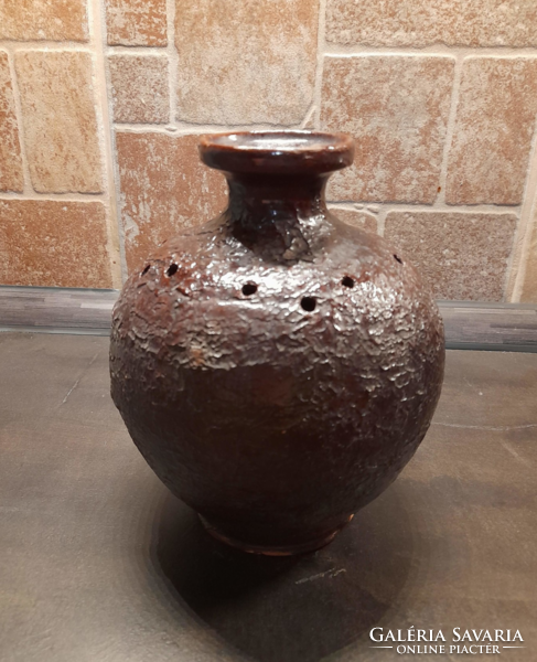 Old rustic glazed ceramic vase with decorative holes
