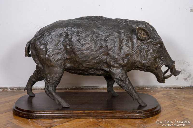 Large bronze boar statue on a wooden pedestal