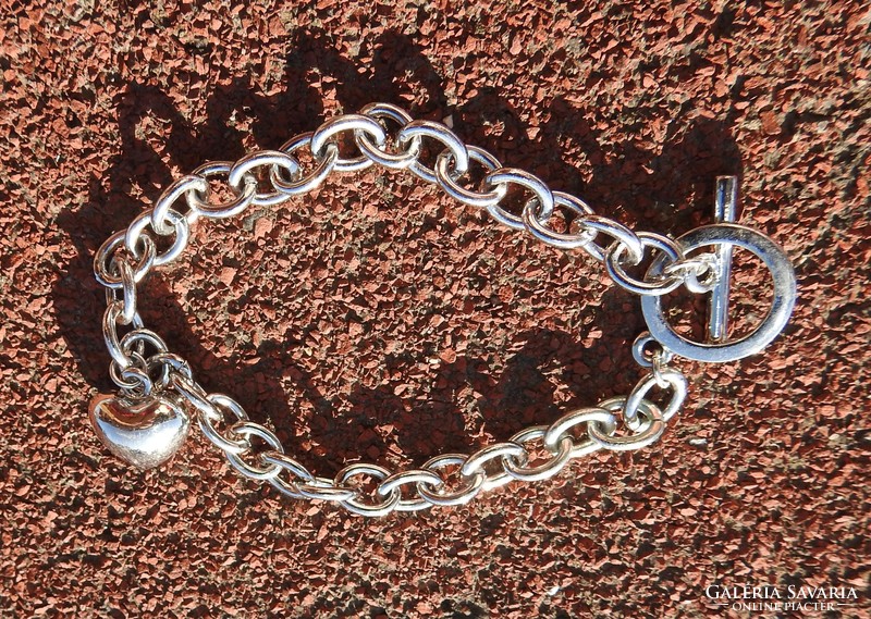 A silver heart with stones on a bracelet