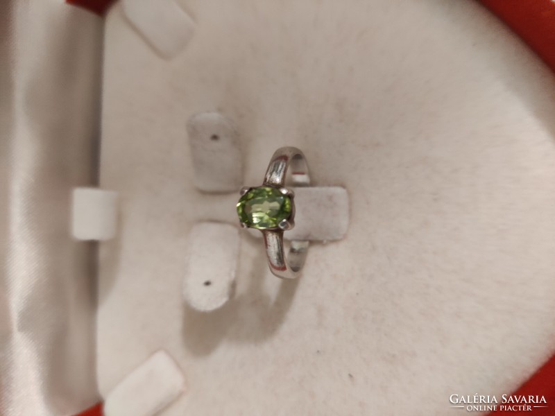Silver ring with green stones in claw socket