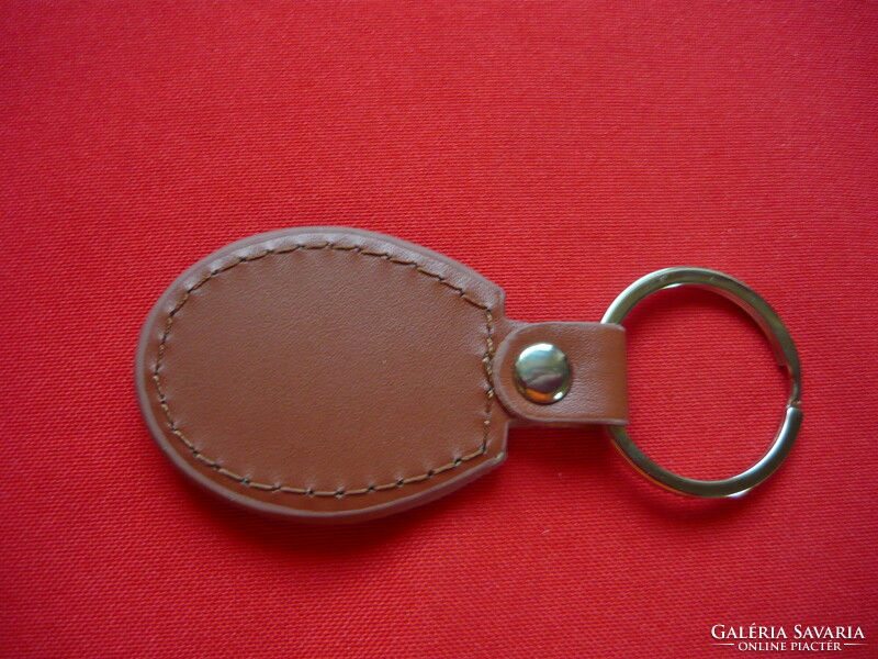 Luaz oval metal keychain on a leather background