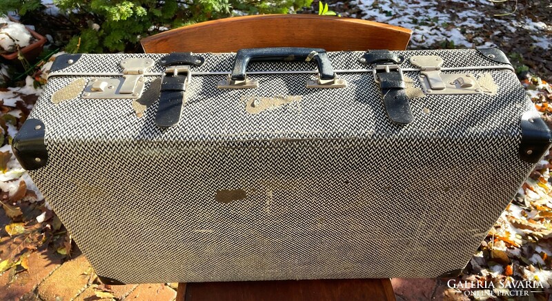 Old herringbone patterned black and white large strap suitcase, retro suitcase