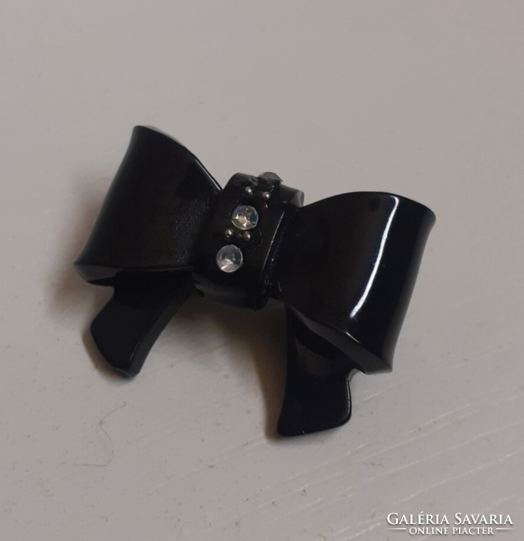 A black bow-shaped brooch in nice condition, studded with tiny white sparkling stones