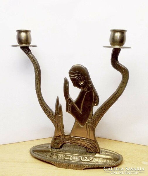 A bronze candlestick in the form of a prayer from the Far East