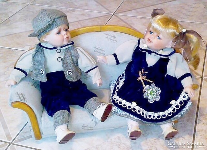 Pair of porcelain dolls dressed in retro folk costumes, boy and girl in handmade clothes