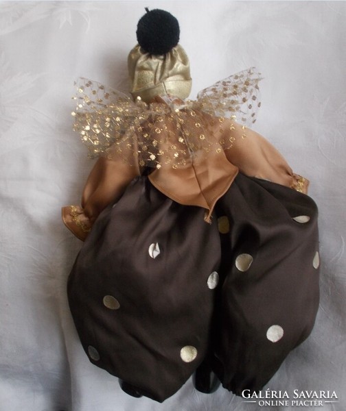 A clown doll with a porcelain head, hands and feet in puffy clothes