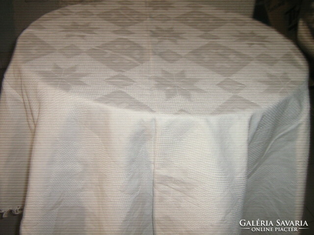 Beautiful white richly patterned large tablecloth with fringed edges