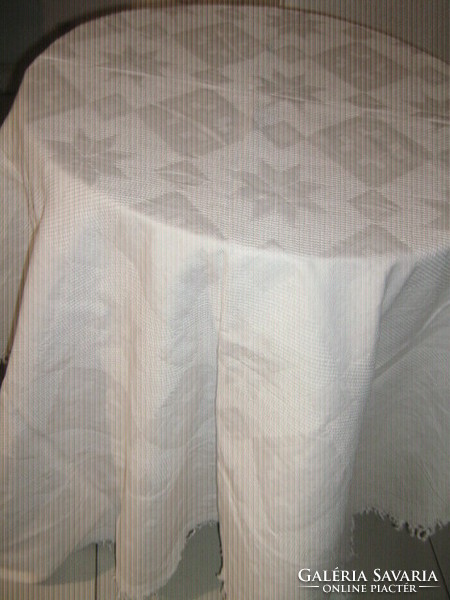 Beautiful white richly patterned large tablecloth with fringed edges