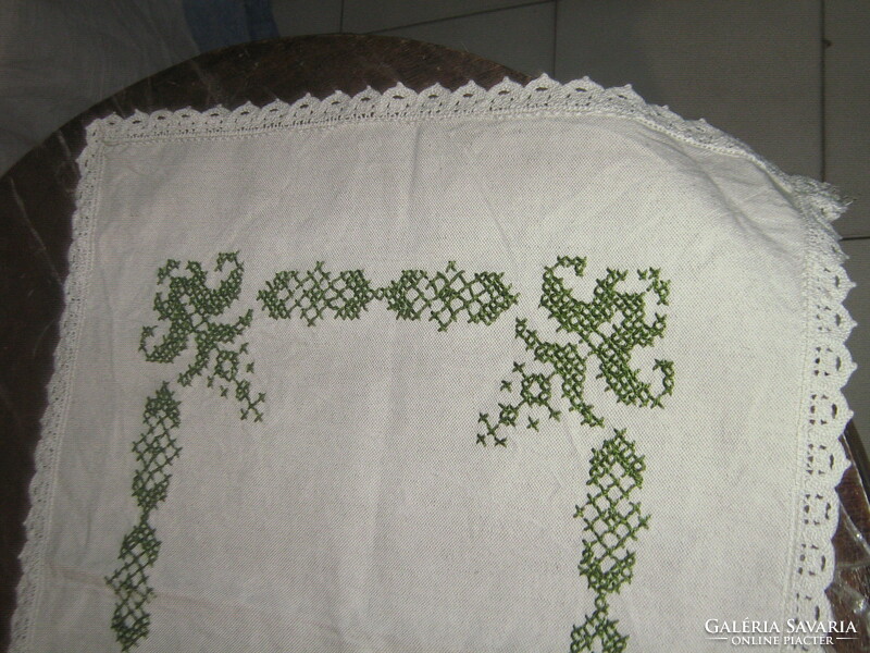 Woven tablecloth runner with a lace edge embroidered with a beautiful green pattern