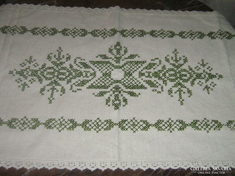 Woven tablecloth runner with a lace edge embroidered with a beautiful green pattern