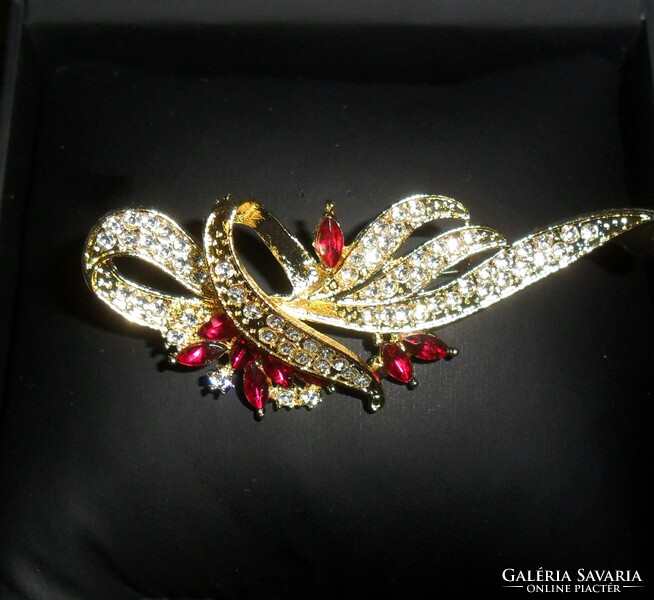 Beautiful, gold-colored brooch decorated with red stones and zirconia. More beautiful than in the pictures!