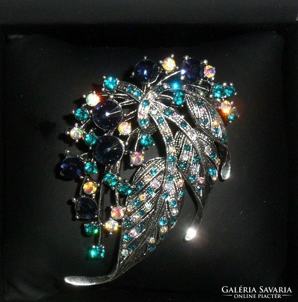 Beautiful, silver-colored, decorated with blue-green-yellow zirconia. More beautiful than in the pictures!