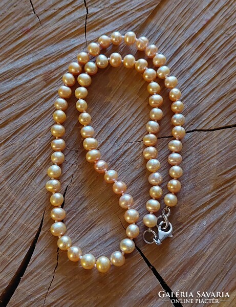 Beautiful gold-colored genuine cultured pearl necklace with silver fittings and knotted lacing