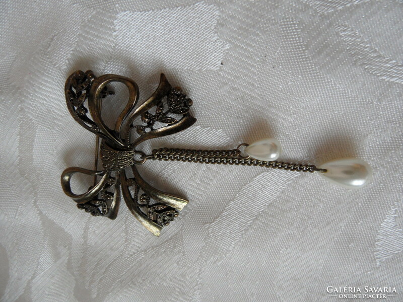 Older bow-shaped metal badge, brooch
