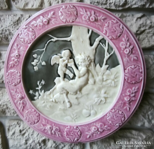 Antique wall plate schütz cilli majolica figural angel and faun .2. A pair is also for sale!