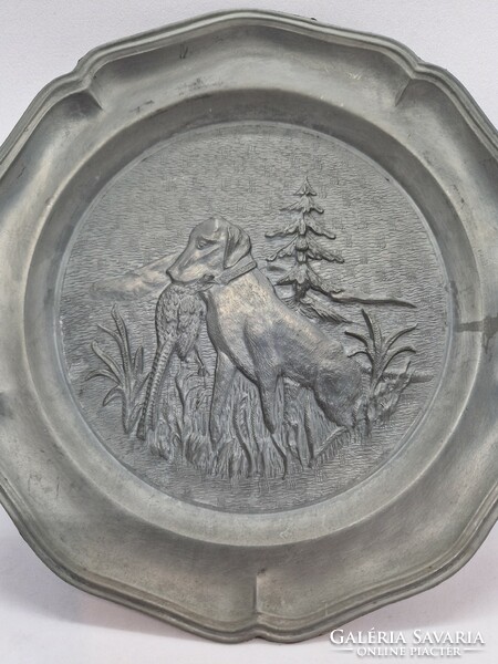 A pair of pewter wall decorations with a hunting scene