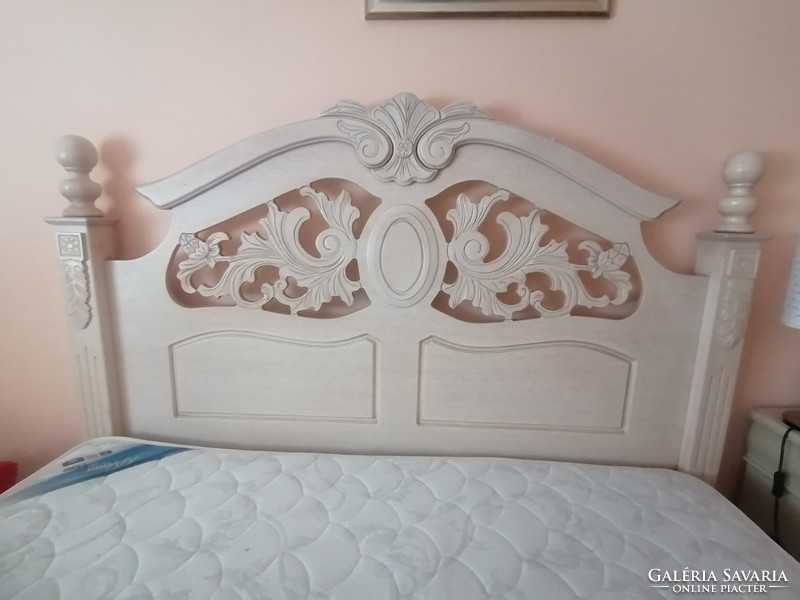 Provençal style double bed with 2 bedside cabinets and lamps.
