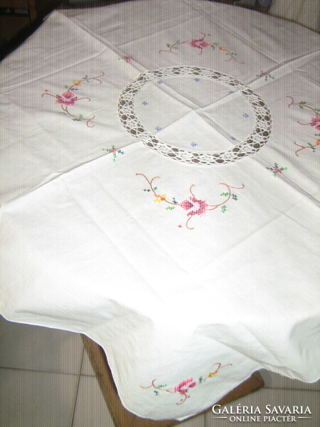 Beautiful crochet doily and floral tablecloth embroidered with tiny cross stitches