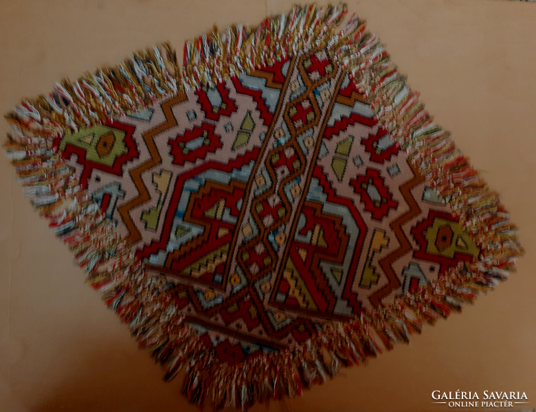 An old embroidered rhombus shape fringed tablecloth with a matching pillow insert