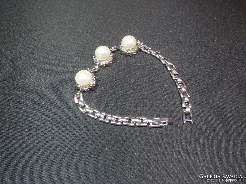 Akoya salt water cultured pearl set in medical grade metal bracelet with crystals around it.