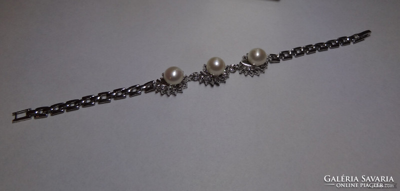 Akoya salt water cultured pearl set in medical grade metal bracelet with crystals around it.