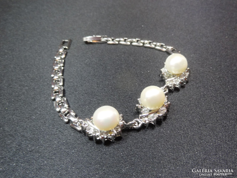 Akoya salt water cultured pearl set in medical grade metal bracelet with crystals around it.