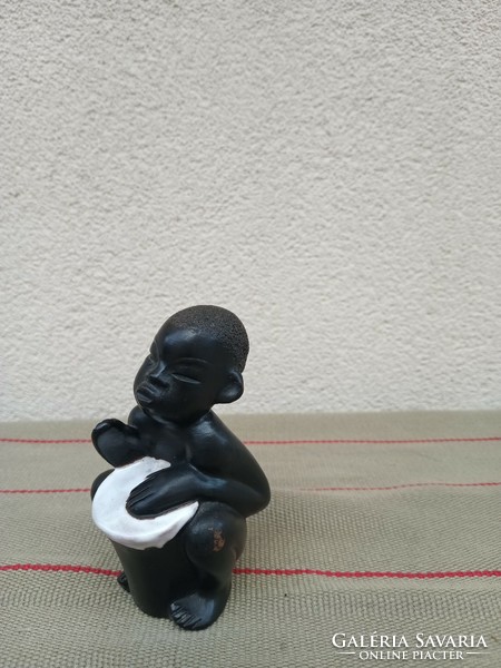 African boy playing terracotta drums. Design: Leopold Anzengruber. Negotiable!