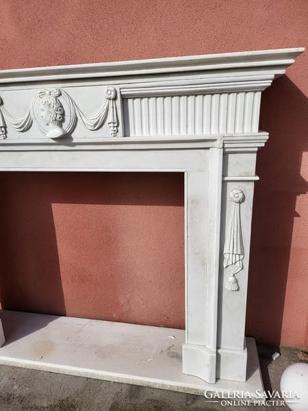 Classic marble fireplace with an antique portrait