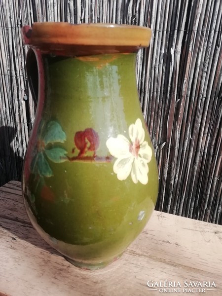 Old green jug with floral pattern
