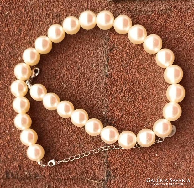 Clair's white pearl string necklace with large eyes