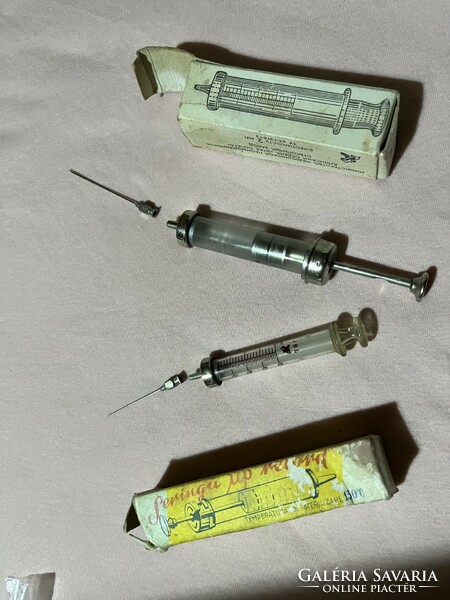 Old glass syringes with metal needles and their boxes