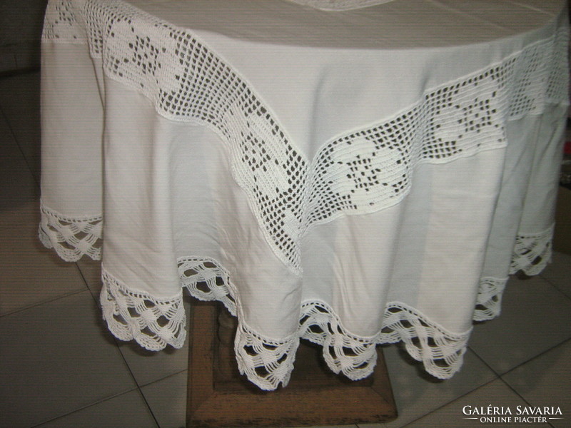 Beautiful white hand-crocheted round tablecloth with a crocheted flower insert