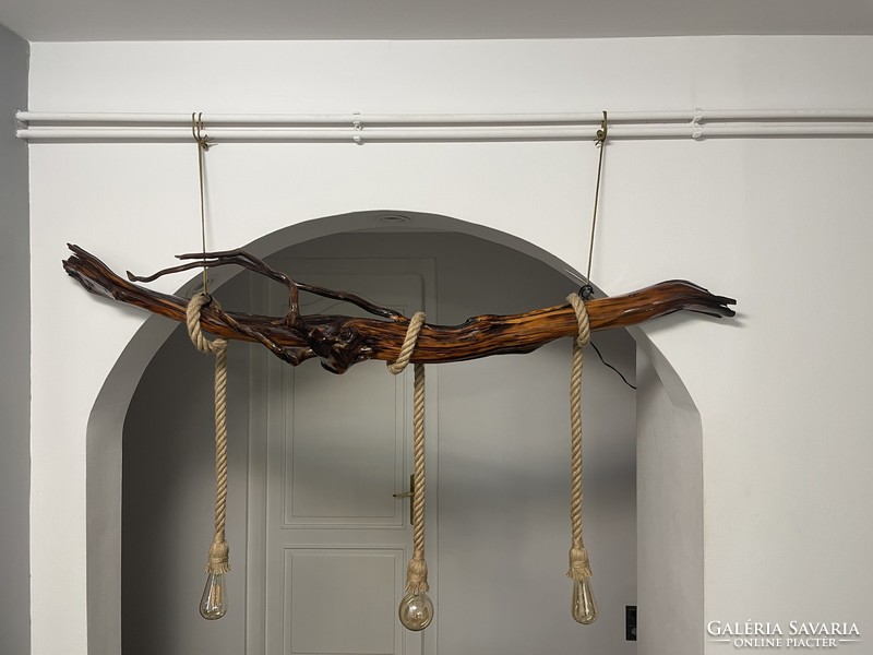 A unique ceiling lamp hanging on a chain made of yew roots,