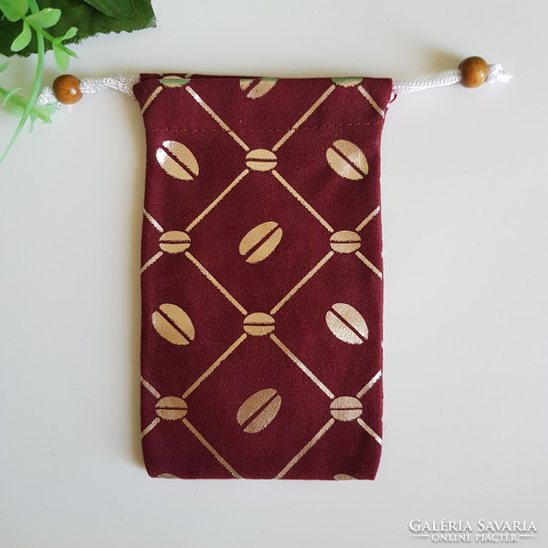 New retro textile phone case with gold coffee bean pattern on a burgundy base with a cord that can be hung around the neck