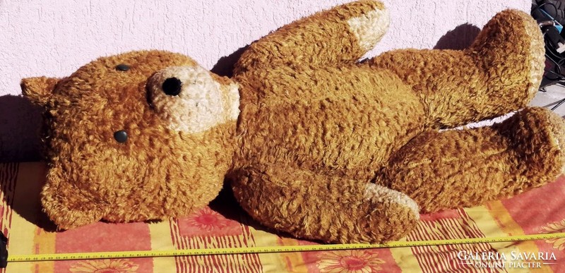 Antique large teddy bear stuffed with straw. Moving with rotating limbs