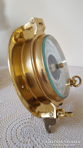 Decorative brass barometer in the shape of a ship's window