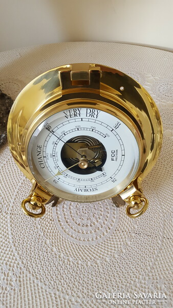 Decorative brass barometer in the shape of a ship's window