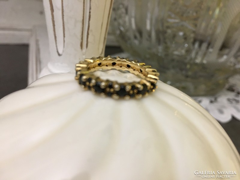 A silver ring with a symbol of endless love, beautifully crafted, surrounded by onyx stones in gold