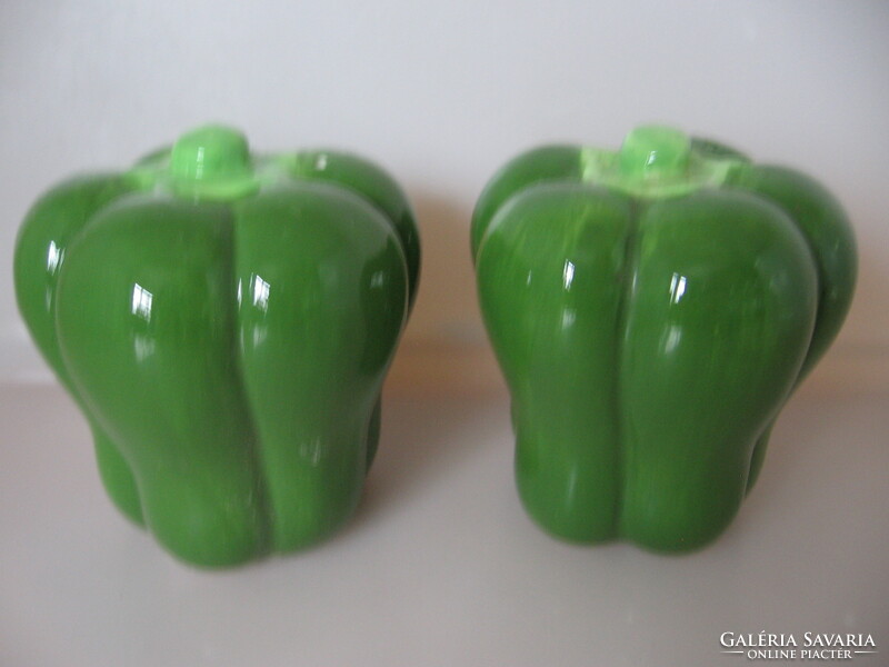 A pair of salt, pepper shakers and table spice holders in the form of green peppers
